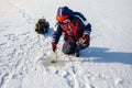 A fisherman is fishing with a winter spinning rod on a frozen lake Royalty Free Stock Photo