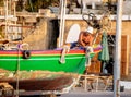Fisherman fixing his boat in a small port