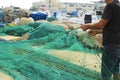 Fisherman fixing the nets in the dock of Santa Pola