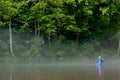 Fisherman fly fishing in a misty river Royalty Free Stock Photo