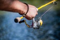 Fisherman hand holding fishing rod with reel. Fishing Reel. Fishing Rod with Aluminum Body Spool. Fishing Gear. Fish Royalty Free Stock Photo