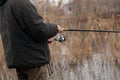 Fisherman hands holding rod with reel close-up