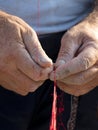 Fishermans` hands repairing red fishing net