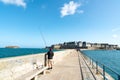 Fisherman on the harbor wall jetty in the historic French town of Saint-Malo