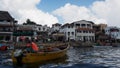 Fisherman and his boat at Lamu Island, Kenya.  A row of seafacing hotels and other buildings are visible in the background Royalty Free Stock Photo