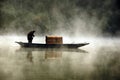 Fisherman and his boat in a misty morning Royalty Free Stock Photo