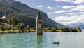 Fisherman in his boat near the submerged bell tower in Resia lake, Curon, South Tyrol, Italy Royalty Free Stock Photo