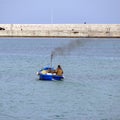 Fisherman with his old diesel powered boat with steaming muffler in the sea Royalty Free Stock Photo