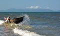 Fisherman and his traditional round boat (tung chai). An Bang beach. Hoi An. Vietnam