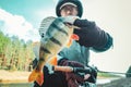 Fisherman holding bass in hand. Freshwater fishing.