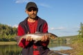 Fisherman holding a beautiful salmon.