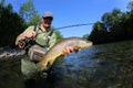 Fisherman holding big brown trout