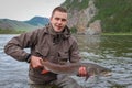 A fisherman holding a big taimen trout caught on a river in Mongolia, Moron, Mongolia