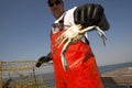 A fisherman holding a crab
