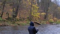 A fisherman holding a fishing rod and turning a reel handle. A man catches fish in a mountain river Royalty Free Stock Photo