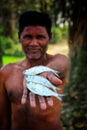 fisherman holding small fishes in hand in nice blur background