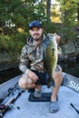 Fisherman Holding Trophy Largemouth Bass Fishing in Boat Royalty Free Stock Photo