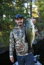 Fisherman Holding Trophy Largemouth Bass Fishing in Boat Royalty Free Stock Photo