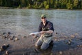 A fisherman holding up a `Jack` Chinook or King Salmon, Skeena River, Canada