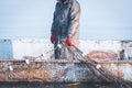 Fisherman holds a frozen fishing net in his hands