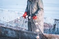 Fisherman holds a frozen fishing net in his hands