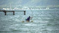 Fisherman of lake in action when fishing on twilight, Thailand. Royalty Free Stock Photo