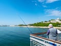 Fisherman on the bridge with a pier and jumping and walking people in Burgas, Bulgaria