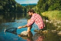 Fisherman man on river or lake with fishing rod. Catching trout fish. Royalty Free Stock Photo