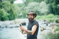 Fisherman man on river or lake with fishing rod. Hipster bearded man catching trout fish. Royalty Free Stock Photo