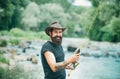 Fisherman man on river or lake with fishing rod. Hipster bearded man catching trout fish. Royalty Free Stock Photo