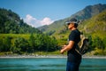 Fisherman on the mountain river at the nice summer day. Trout fly fishing in the mountain river with mountains in background Royalty Free Stock Photo