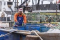 Fisherman moving bait barrels on lobster boat Direction Royalty Free Stock Photo