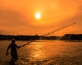 Fisherman netting fish at sunset Royalty Free Stock Photo