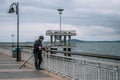 A fisherman overlooking the sea. Fishing rods resting on the side waiting for fish. Fisherman on a sea bridge. Royalty Free Stock Photo