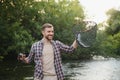 Fisherman picking up big rainbow trout from his fishing net