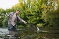 Fisherman picking up big rainbow trout from his fishing net