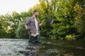 Fisherman picking up big rainbow trout from his fishing net