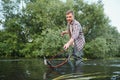 Fisherman picking up big rainbow trout from his fishing net