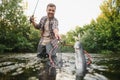 Fisherman picking up big rainbow trout from his fishing net