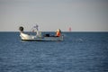 a fisherman picking up the net in ligurian sea fishing from small boat