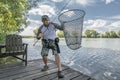 Fisherman with pike fish in fishing landing net Royalty Free Stock Photo