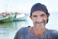 Fisherman, portrait and rugged man with smile, boats and fishing trawler in ocean. Wrinkles, aged and mature happy male Royalty Free Stock Photo