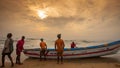 The fisherman pulling the boat in beach at during sunrise golden hour