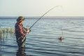 Fisherman in a red shirt caught a pike-perch in a freshwater pond Royalty Free Stock Photo