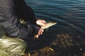 The fisherman releases the caught pike fish back into the river.