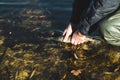 The fisherman releases the caught pike fish back into the river.