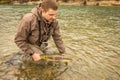 A fisherman releasing a chum salmon back into the river, while wading Royalty Free Stock Photo