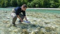 A fisherman releasing a rainbow trout back into the Soca River in Slovenia