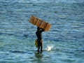 Fisherman releasing small fish from his nets, Mauritius