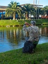 A fisherman removes his fishing rod on the shore of a city pond. Fisherman in Batumi